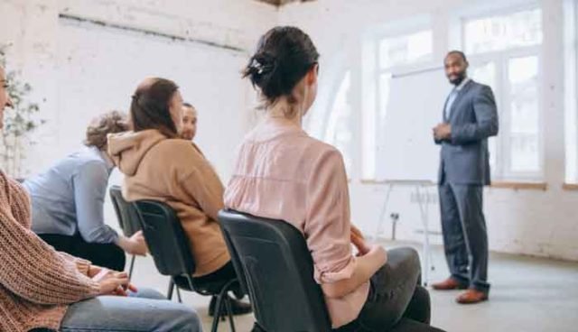 male-speaker-giving-presentation-in-hall-at-university-workshop-audience-or-conference-hall-1_p4379_thumb_resized-(1)
